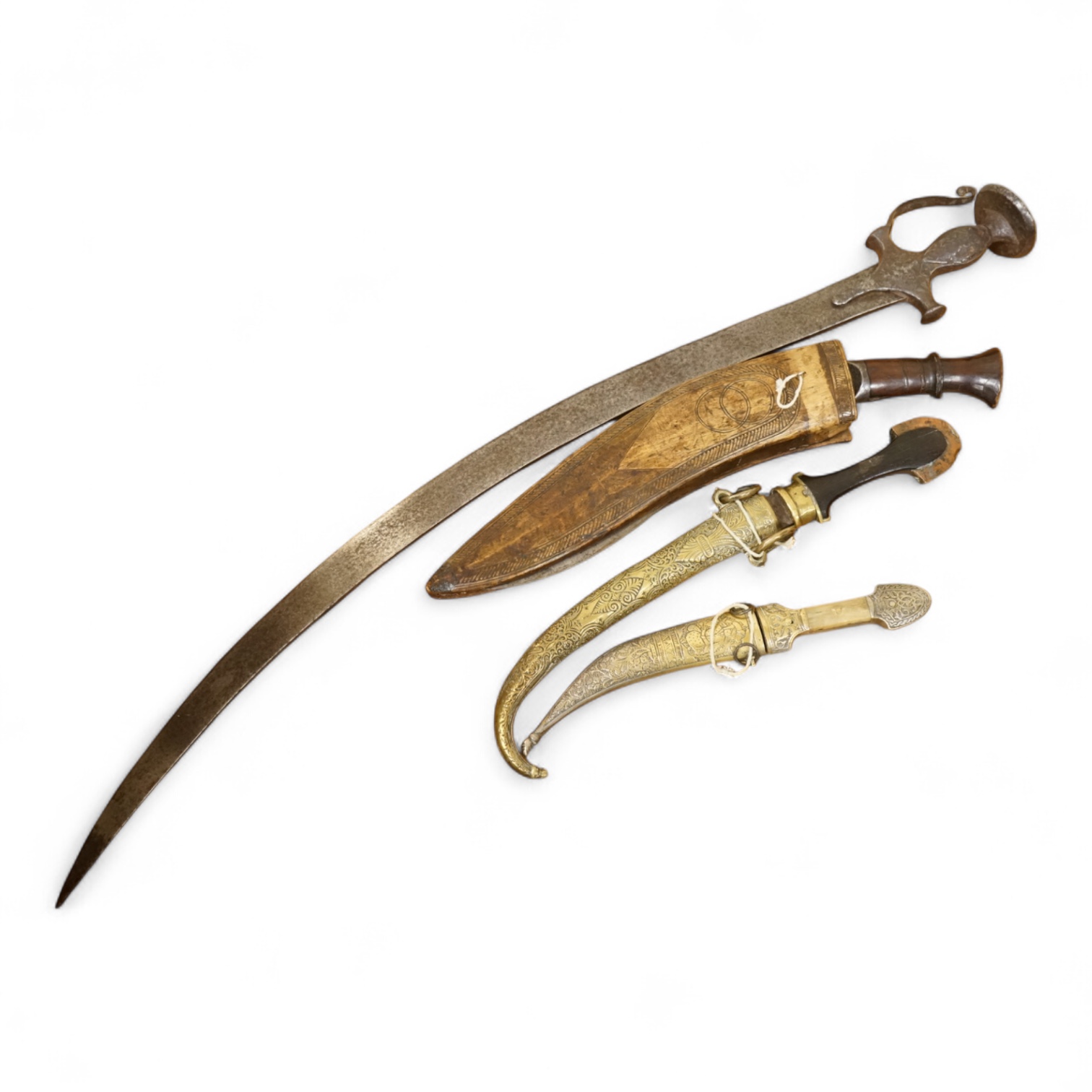 An Indian sword tulwar, the iron hilt with traces of chiselled and inlaid decoration, together with a kukri in its wooden scabbard, a Syrian jambya and a Moroccan jambiya (4)